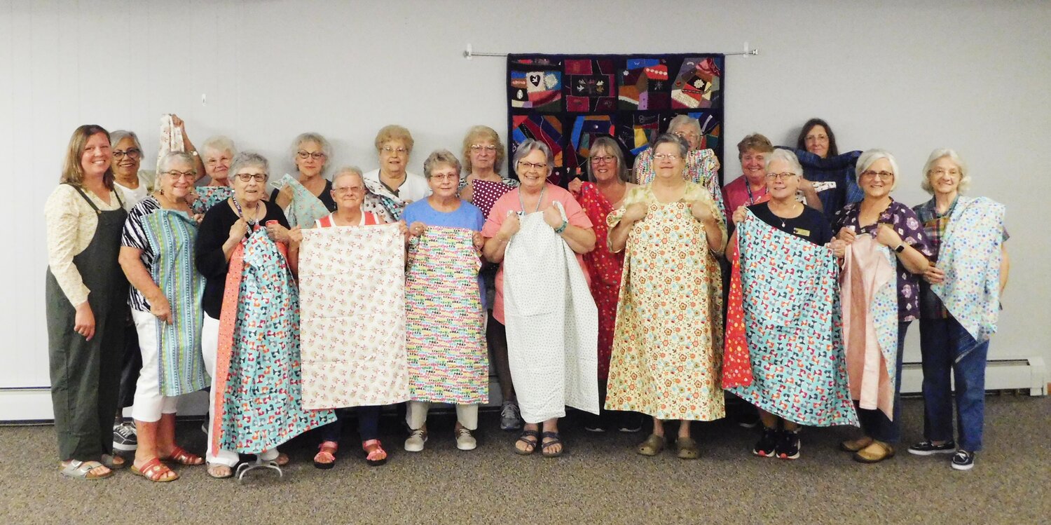 Eighteen members of the Clare County Crazy Quilters are joined by their July 17 guest speaker Keri Withers as they proudly hold up the lap quilt tops they’ve sewn with the intent to donate them to children who can benefit from the comfort they provide.